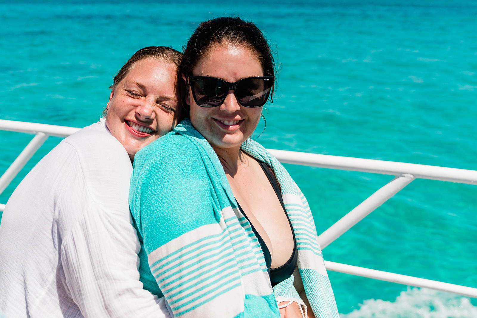 Two female friends are hugging together, enjoying Ningaloo’s tours and cruises.