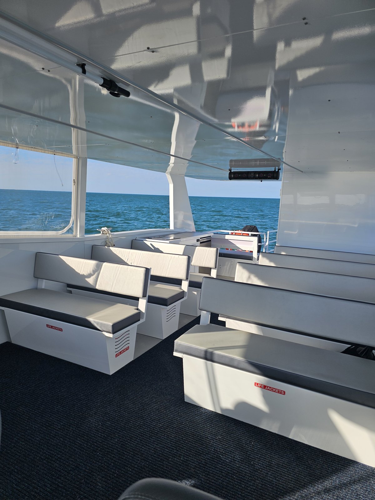 Cushioned bench seating and life jacket lockers on board the power catamaran