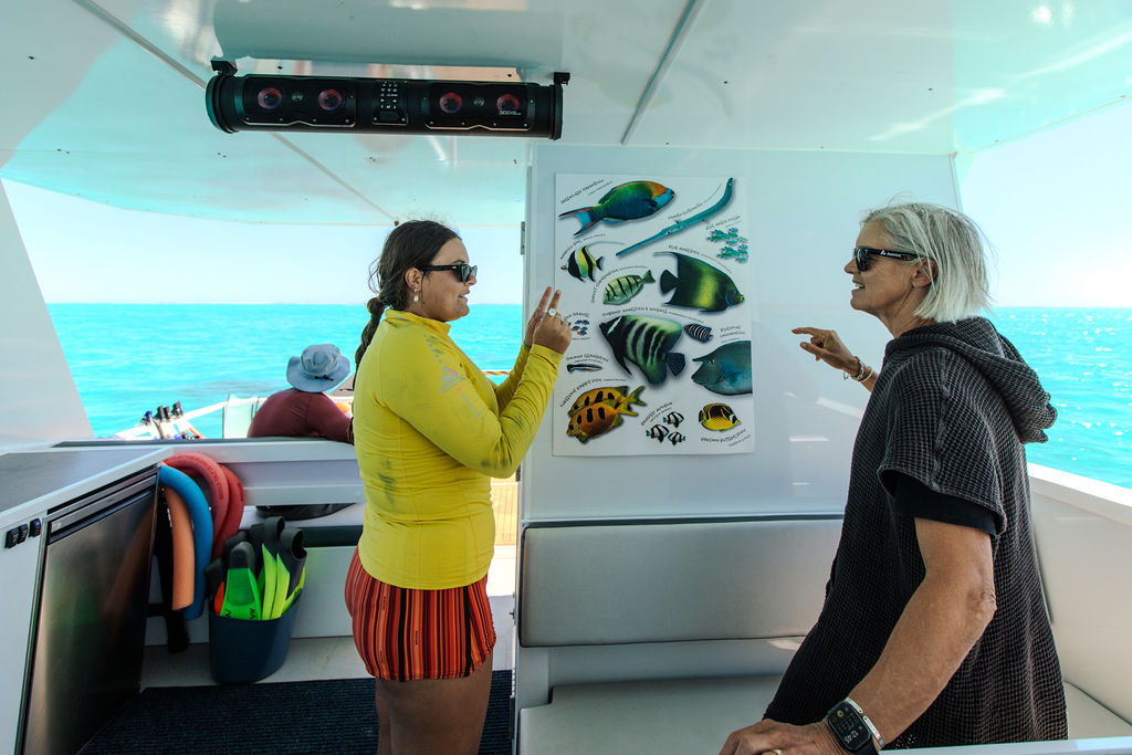 View Ningaloo guide sharing a fish identification chart aboard Turquoise Girle